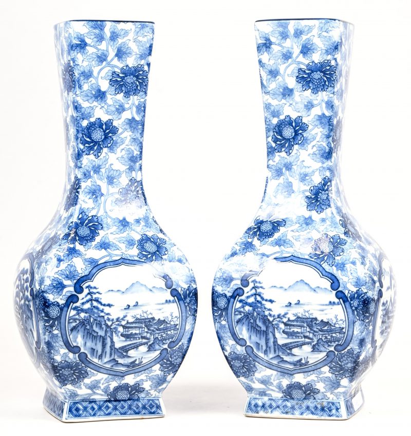 Een paar blauw-witte Chinees porseleinen vazen met floraal en landschapsdecor.