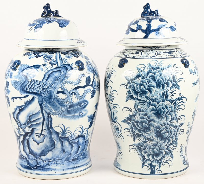 Een paar Chinees porseleinen dekselvazen met blauw en wit decor. Met fo-honden bovenaan.