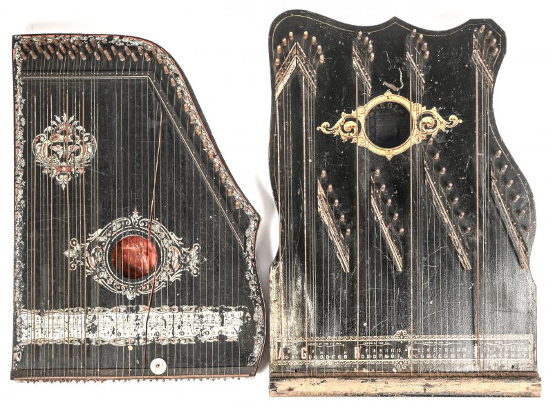 Een lot van 2 houten Citers of Zithers, gemerkt met label binnenin, waarvan 1 “AEOL” Een Amerikaanse Harp Zither, A.Eichler Company. Medio 1900-1925. Barst overlangs in top. En 1 gemerkt "Deutsch-Amerikanische Guitar Zither”, waarvan barst in voor en achterzijde van het houtwerk.
