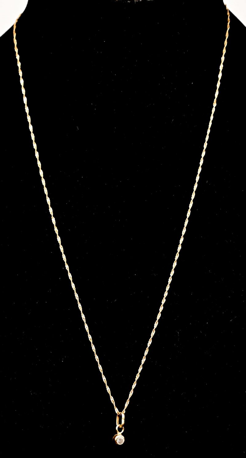 Een 14 kt geelgouden fijne schakelketting met hanger bezet met een fantasie steentje.