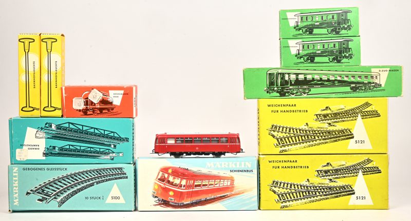 Een lot modeltrein onderdelen, waaronder: de 3016 Schienenbus, 2 x 4040 Local  Passenger Coach, 4022 D-Zug-wagen, 4501 Kesselwagen ESSO. 5100 Curved Track Section, 7168 Gerades Rampenstück, 2 x 5121 Weichenpaar für Handbetrieb, 2 x 7047 Bahnhofsleuchte.