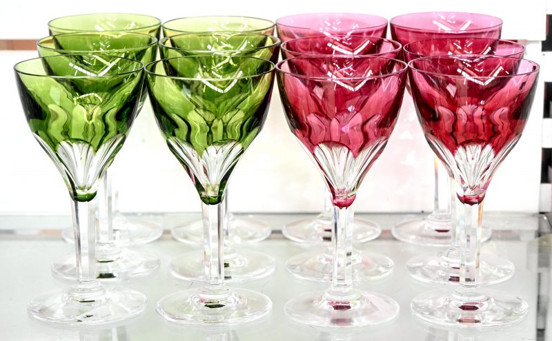 Een lot van twaalf geslepen kristallen glazen op voet met gekleurde kelken, 6 groene en 6 roze. Niet gemerkt.