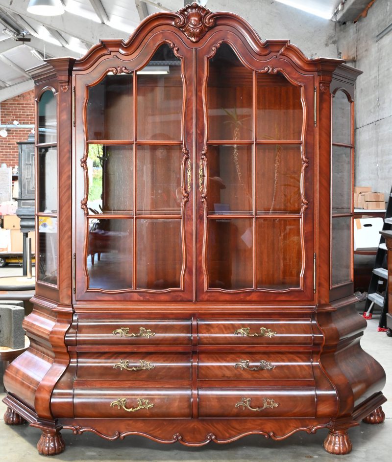 Een tweedelige vitrine in Hollandse stijl met onderaan zes laden en twee beglaasde deuren bovenaan.
