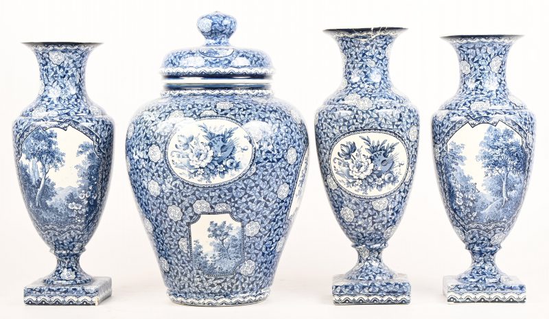 Een schouwgarnituur bestaande uit een dekselvaas en twee amfoor vormige vazen. Van blauw-wit geglazuurd aardewerk, gemerkt; Villeroy & Boch. Toegevoegd een vaas met gelijmde schade aan de kraag.