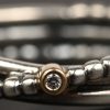 Een zilveren ring 925 ‰ bezet met één briljantje in goud gezet.