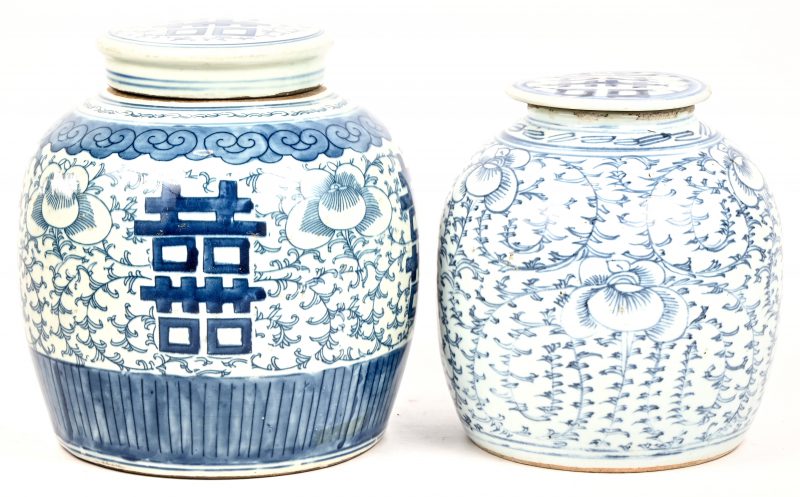 Een lot van twee gemberpotten, blauw-wit geglazuurd Chinees aardewerk. Met een decor van lotusbloemen en het symbool voor een lang leven op de deksels. Van de kleinste gemberpot mist het deksel enkele chips.
