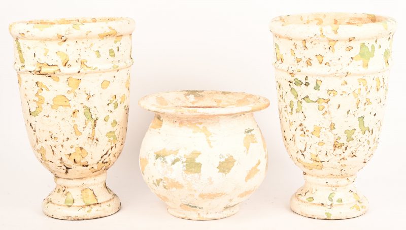 Een paar aardewerken tuinvaasjes met een ‘old paint’ patina. Toegevoegd; een bolvormige kruik. Uit de collectie; House Of Porters.