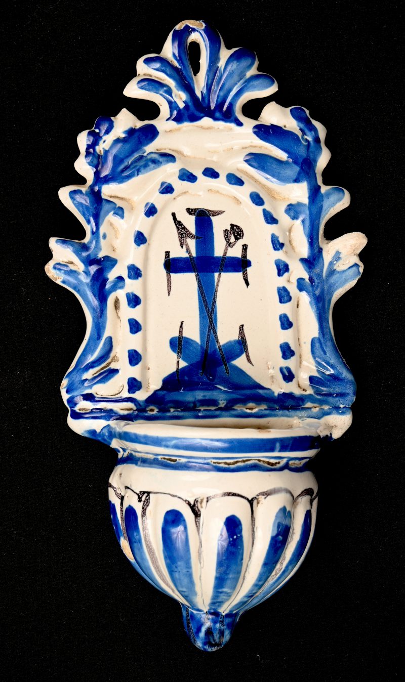Een antiek wijwatervat van blauw-wit geglazuurd aardewerk. Heeft een beetje schilferschade.