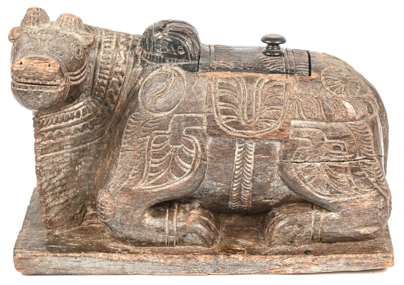 Een houten Indisch koffertje met deksel, in de vorm van een liggende waterbuffel “Nandi”. Het Rijdier van “Lord Shiva”.