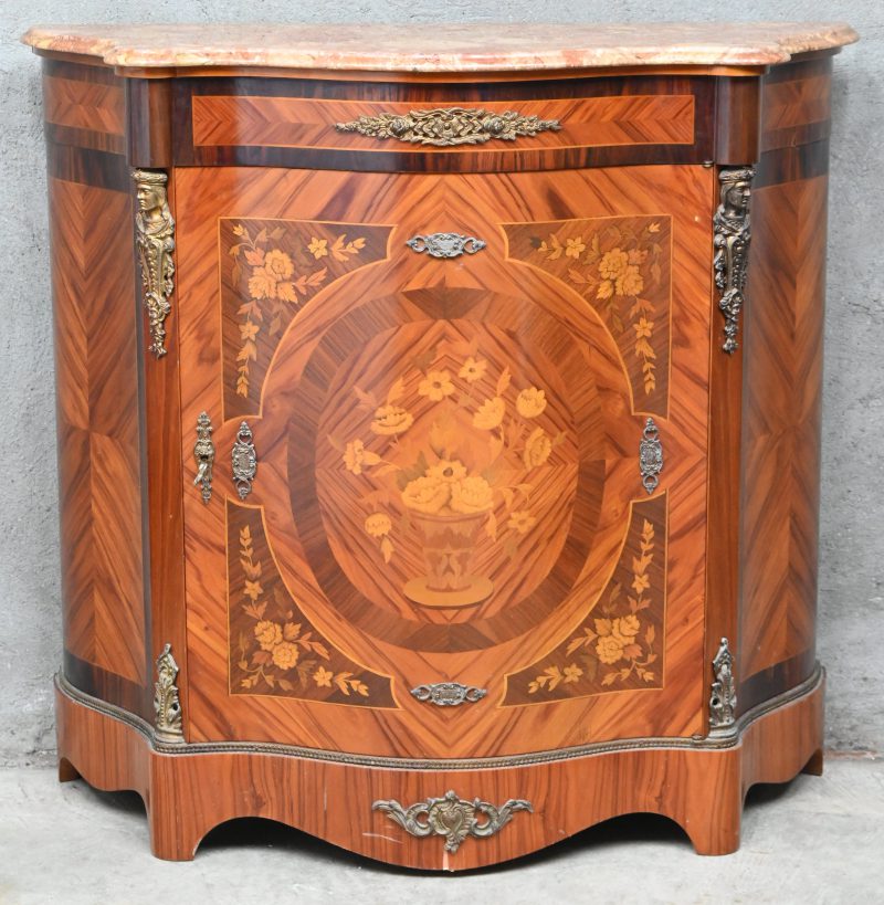 Een commode in marquetterie en marmeren blad met gebombeerde front.