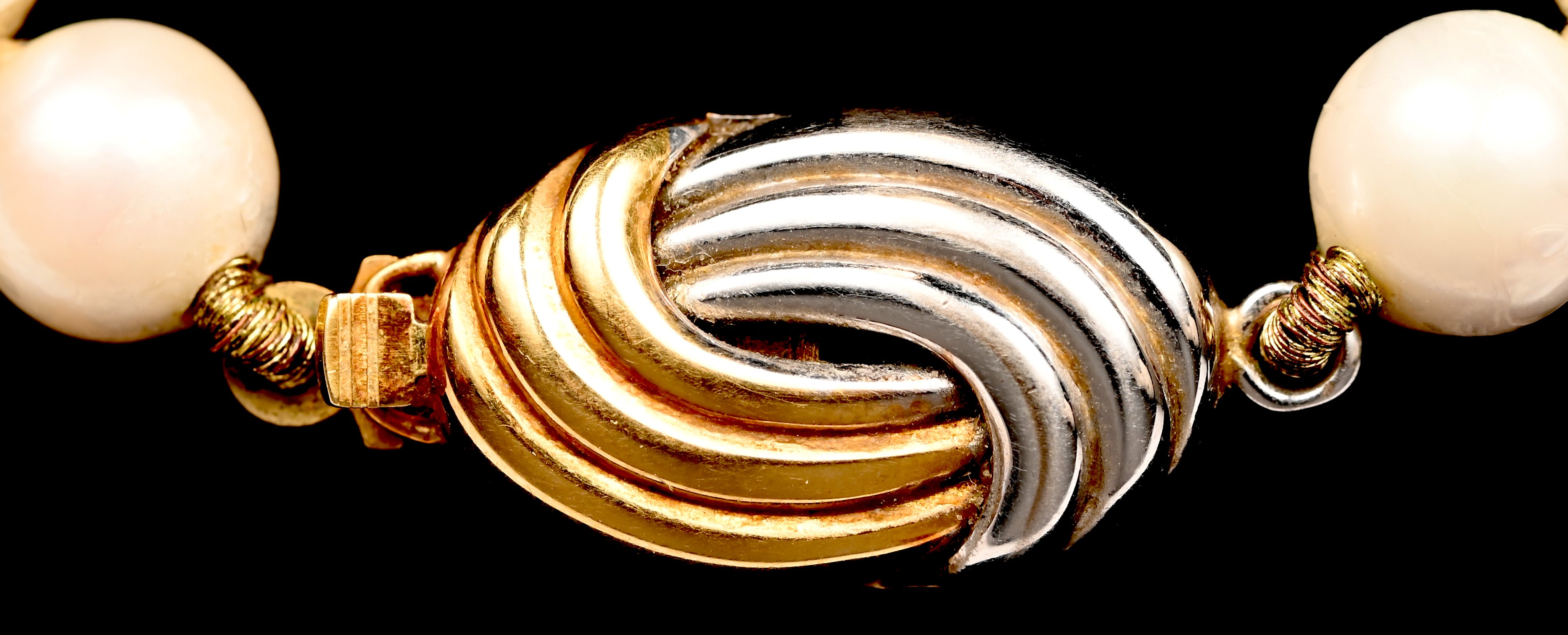 Een parelhalssnoer met 18 kt wit en geelgouden slot Een parelhalssnoer met 18 kt wit en geelgouden slot.