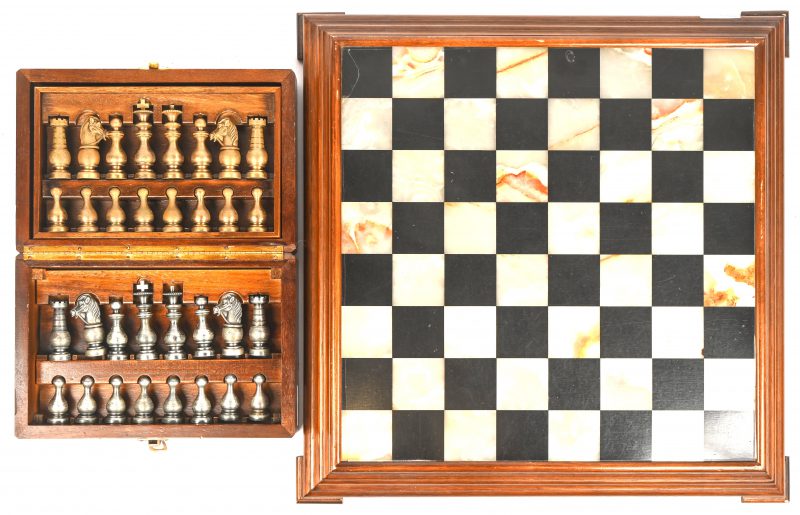 Een schaakbord van marmer en onyx in mahoniehouten frame, met schaakset in messing en tin, in de stijl van 1969 Dunhill Hong Kong in originele houten etui.