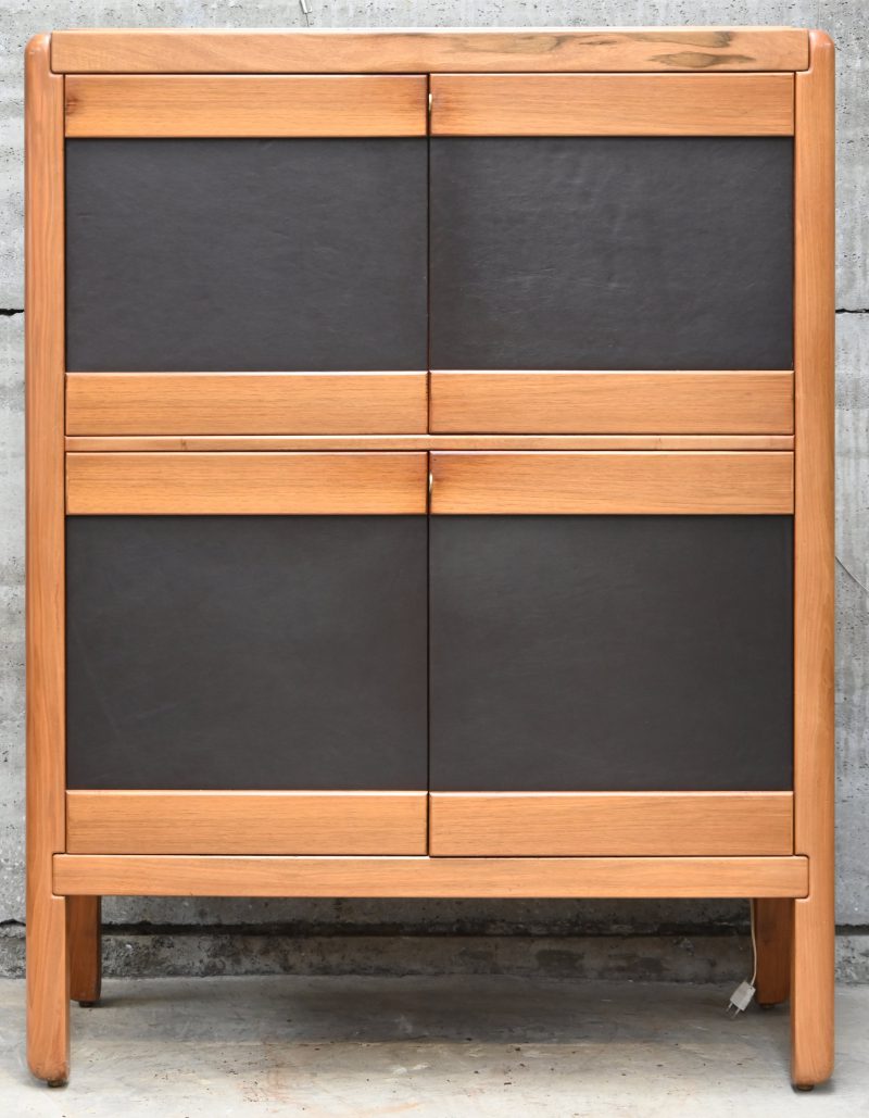 Een eikenhouten barkast met donkerbruin leder op de deurpanelen. Ontwerp Van De Berghe Pauvers. Met schade aan de rug, 1 magneetsluiting is vervangen en 1 is manco.