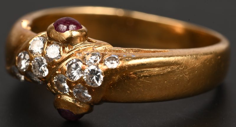 18 karaats geelgouden ring bezet met briljanten met een gezamenlijk gewicht van+- 0,20 ct. en twee robijn cabochons van +- 0,20 ct.