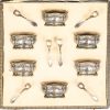 Een set van zes zoutvatjes met lepeltjes in casette. Glazen potjes in zilveren voet, gemerkt 800. Met een nettogewicht van 150 gram zilver. Op de doos een gedenkplaatje als geschenk aan Sir Arthur Yap K.B.E. van de Y.M.C.A.