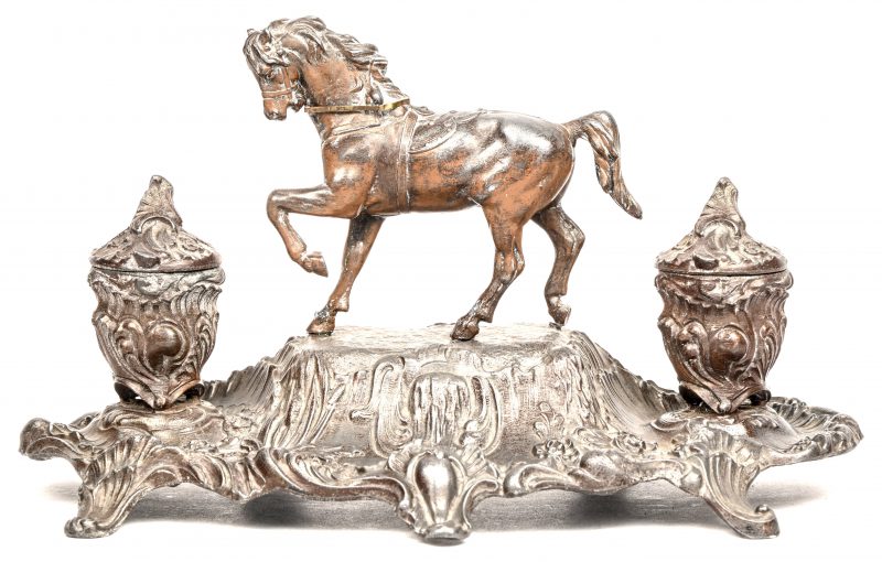 Een Victoriaans metalen inktstel met als centraal ornament een paard in draf. Met de originele glazen inktpotjes.