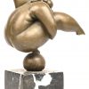 Een bronzen beeld van een voluptueuze dansende vrouw op een bal, met marmeren sokkel, gesigneerd Milo.