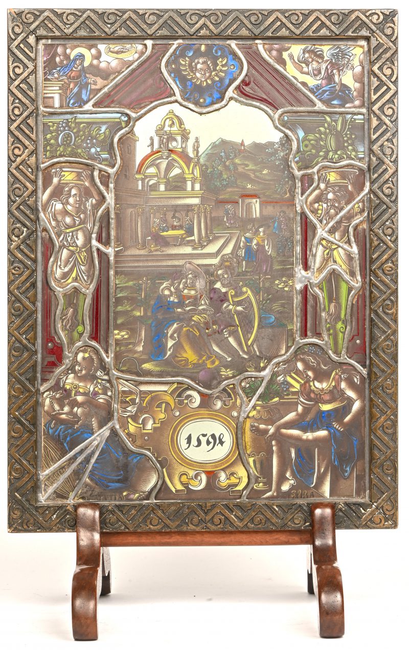 Een glas in lood raam in houten kader op voet, met een tafereel van een adelijk hof. Naar de 16e eeuw.