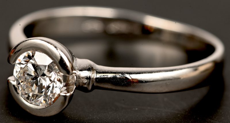 Een 18 kt witgouden ring bezet met centrale briljant van 0,56 ct.