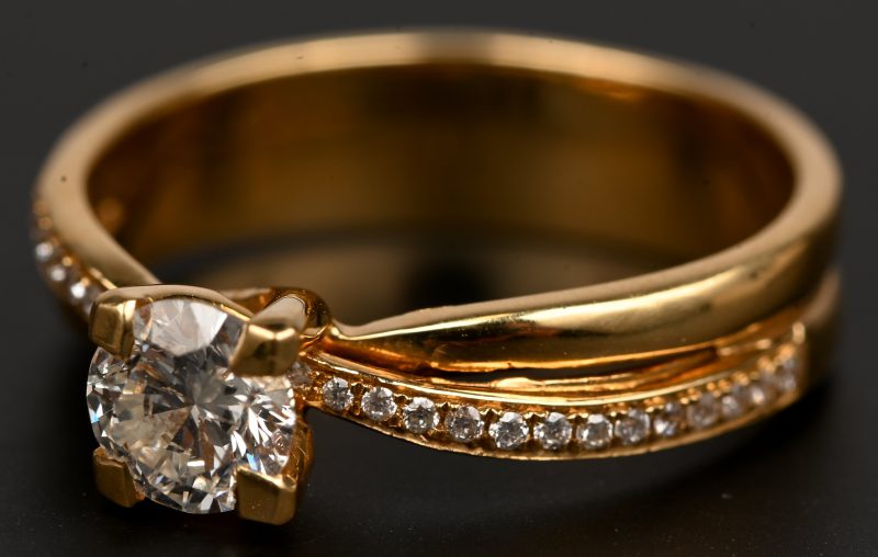 [Nog te bepalen] Een 18 kt geelgouden ring bezet met een centrale briljant van +-0,75 ct en baguetten met een gezamenlijk gewicht van 0,xx ct .
