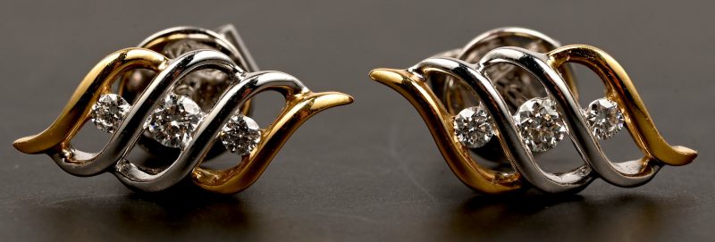 Een paar 18 kt wit en geelgouden oorbellen bezet met briljanten met een gezamenlijk gewicht van 0,22 ct.