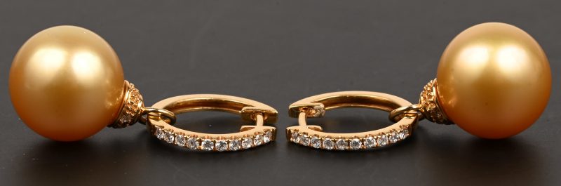 Een paar 18 kt geelgouden oorbellen bezet met een parel en briljanten met een gezamenlijk gewicht van 0,30 ct.