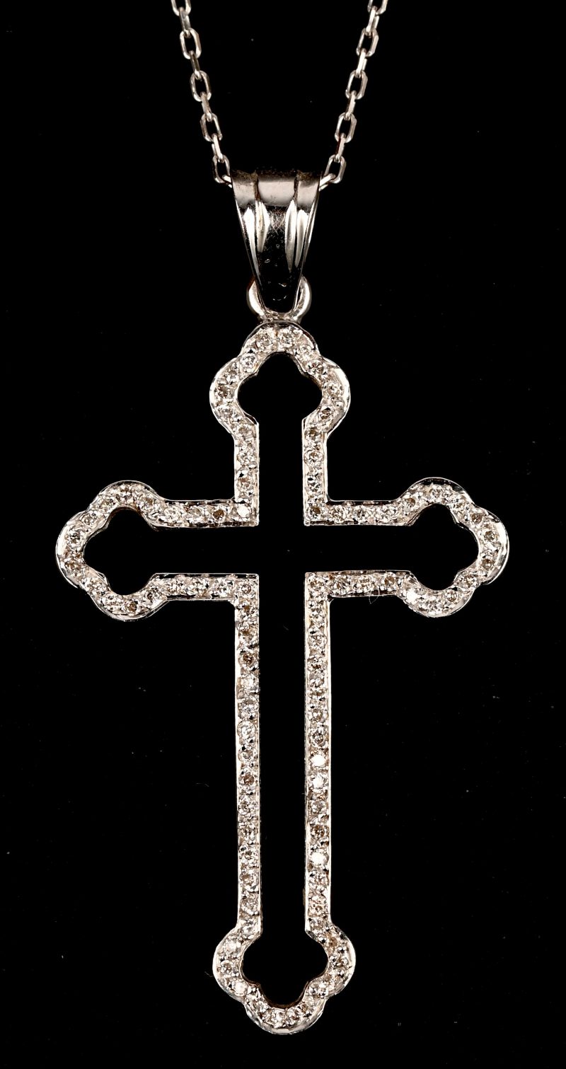 Een 18 kt witgouden ketting met crucifix hanger bezet met briljanten met een gezamenlijk gewicht van 0,26 ct.