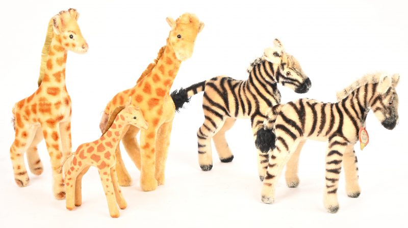 Vijf pluche knuffels waarvan twee zebra’s en drie giraffen, op één giraf na allen gemerkt Steiff.