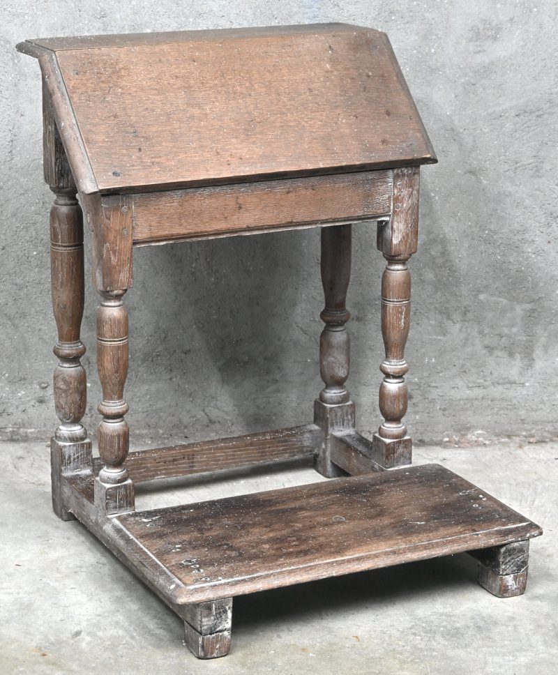 Een sobere houten bidstoel.