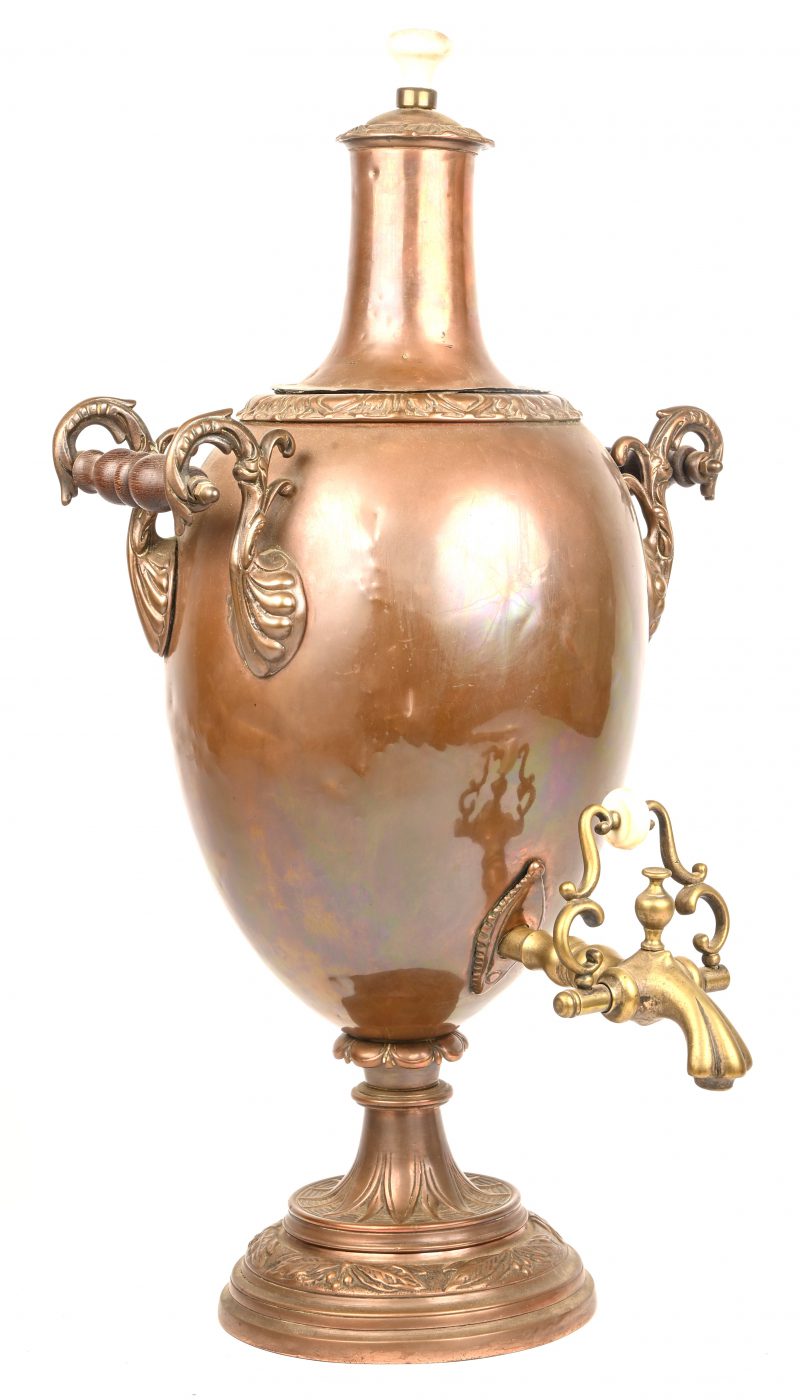 Een oude rood koperen samovar met messing kraan.
