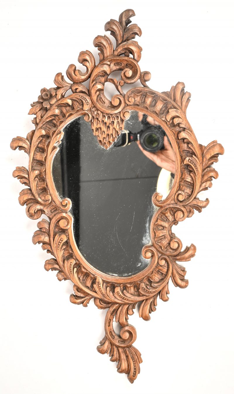 Een spiegel met massief eiken gesculpteerde kader in Rococo stijl.