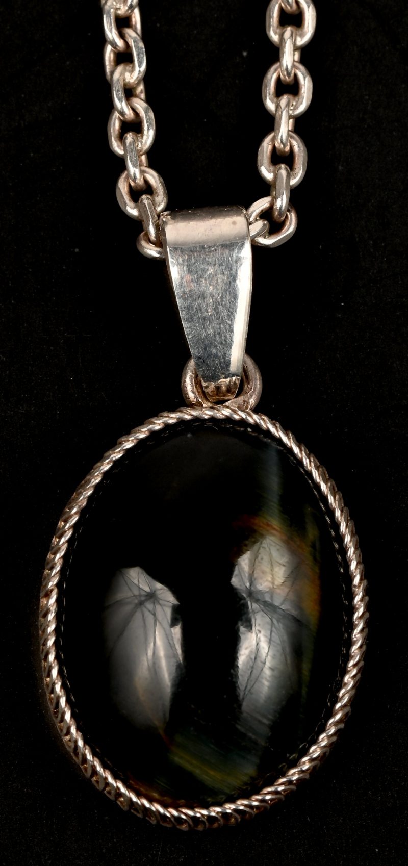 Een zilveren ketting met hanger bezet met een tijgeroog van +- 7 ct.
