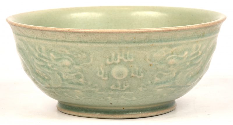 Een kom van celadonkleurig aardewerk. Met een label van het Lu Wu exportbedrijf en de kunsthandelaar Ching Tsai Loo.