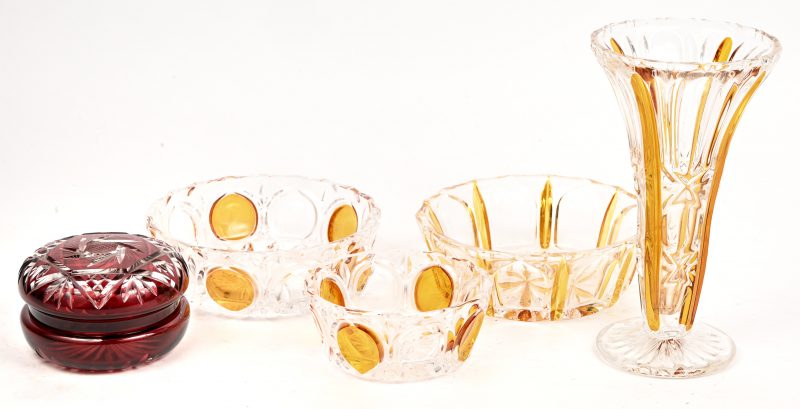 Drie schaaltjes en een vaas van geperst kristal, geel in de massa gekleurd. Toegevoegd een kleine bonbonniere van Boheems geslepen kristal, rood in de massa gekleurd.