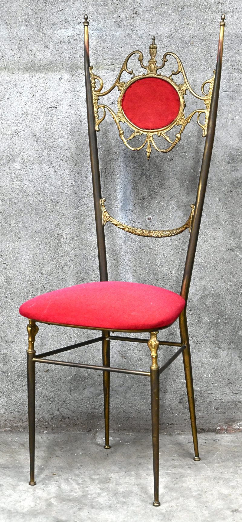 Een messing stoeltje met rood fluwelen bekleding. Hollywood Regency stijl.