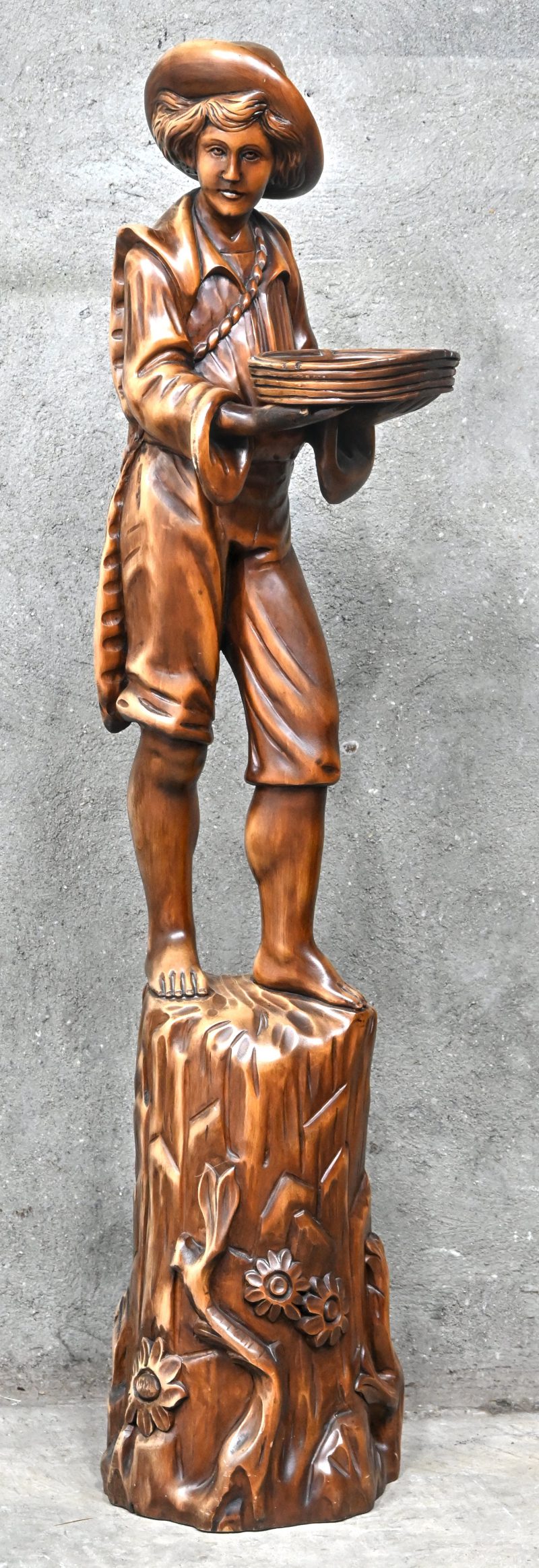 ‘Herdersjongen met mand’, een massief houten beeld.