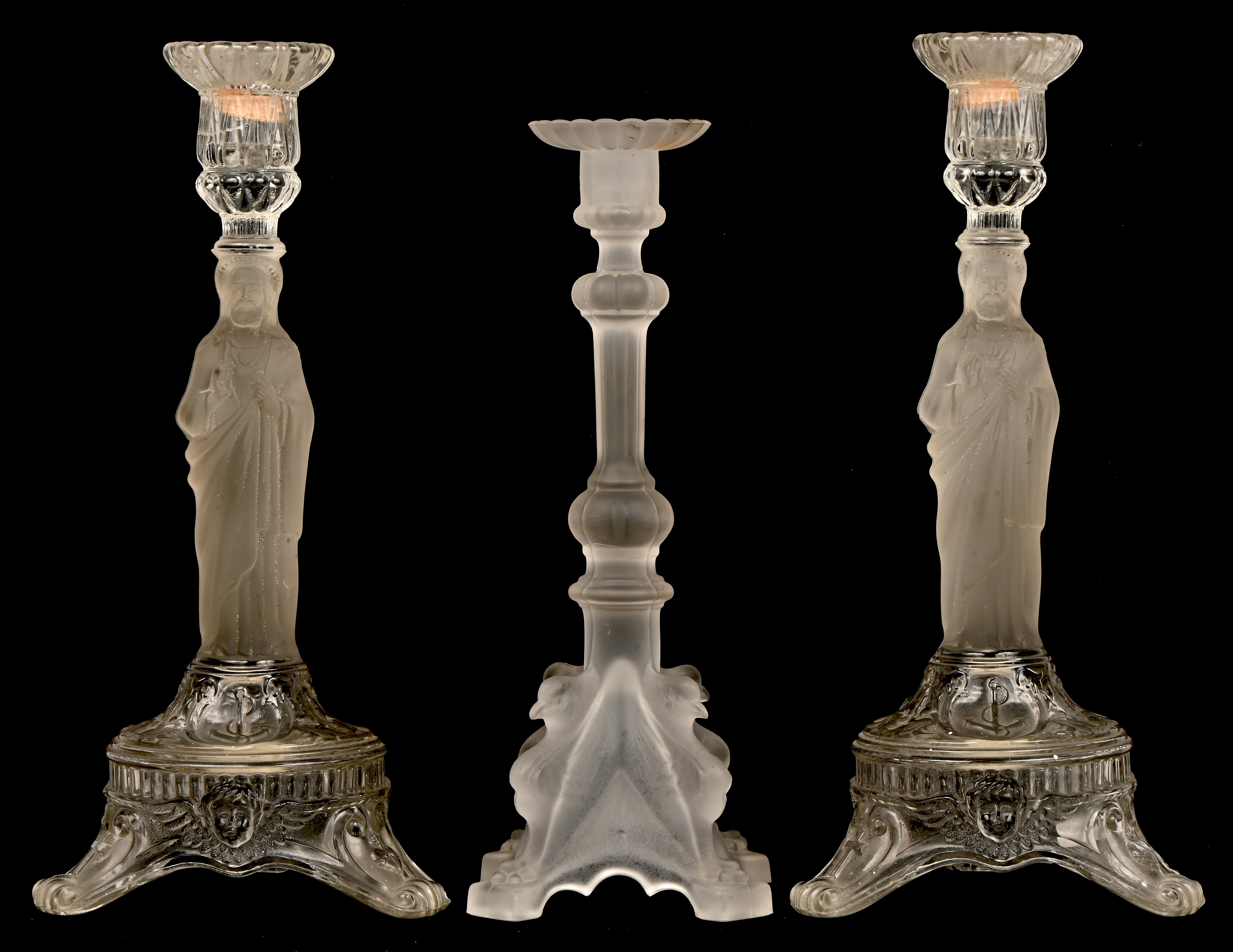 Drie persglazen kandelaars waarvan 2 met heilig hart en 1 gemerkt Val Saint Lambert Drie persglazen kandelaars waarvan 2 met heilig hart en 1 gemerkt Val Saint Lambert.