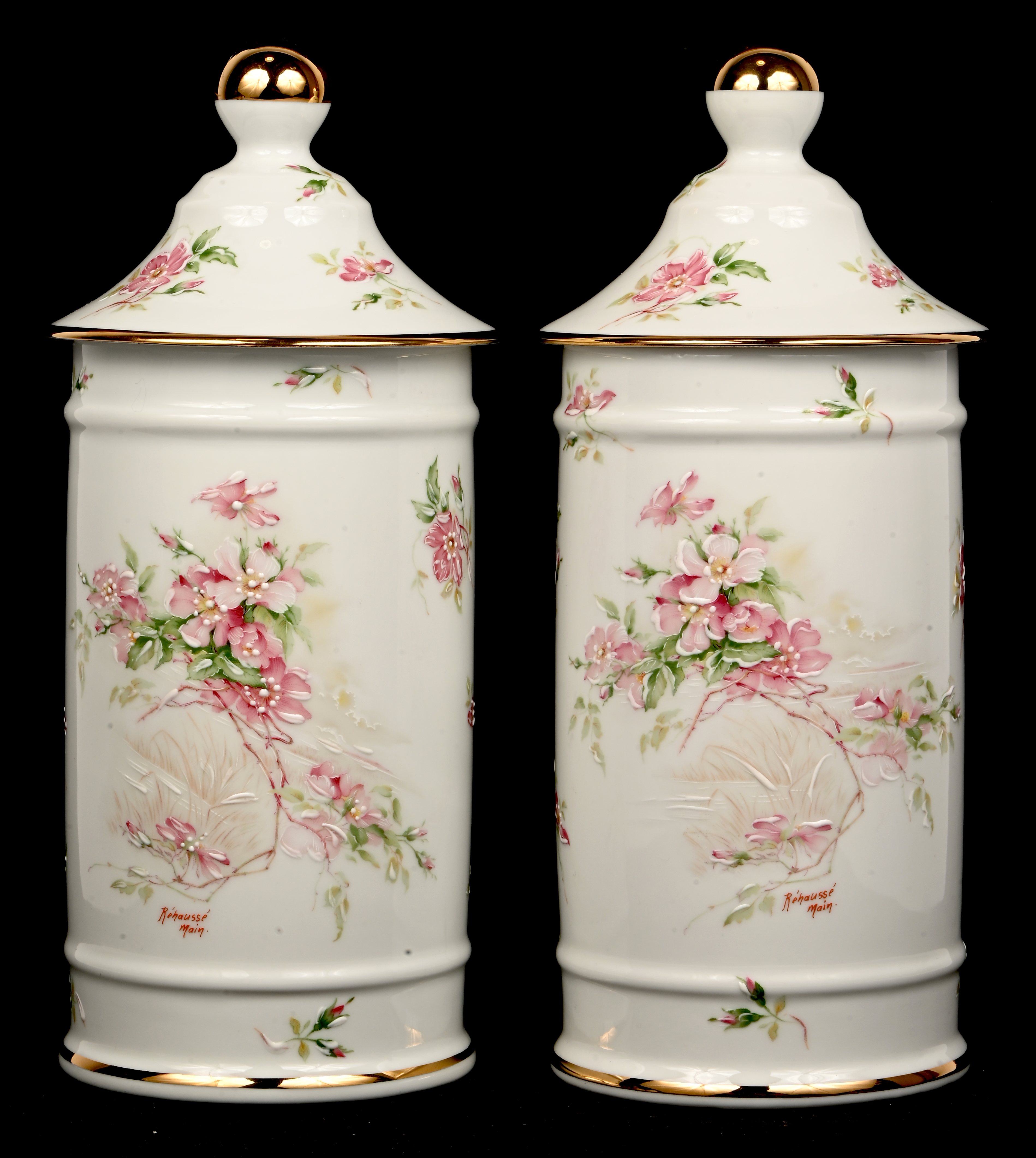 Een paar hoge dekselpotten van beschilderd Limoges porselein. Met een decor van appelbloesem. Gemerkt; Limoges Een paar hoge dekselpotten van beschilderd Limoges porselein. Met een decor van appelbloesem. Gemerkt; Limoges.