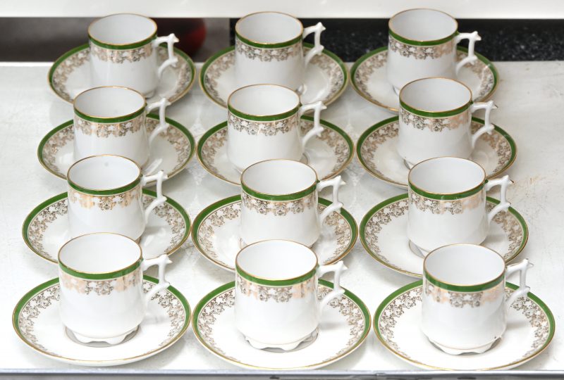 Een set van 12 kopjes en schoteltjes van groen en goudkleurig gedecoreerd porselein.