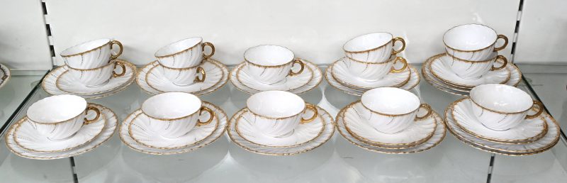 Een set van veertien kopjes, schoteltjes en bordjes. Van Sarreguemines porselein, met goudkleurige accenten.