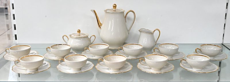 Een koffieserviesje van Zeh Scherzer Bavaria porselein, met koffiepot, melkkan en suikerpot. 12 delig, 1 kopje is manco. Wit met een goudkleurig biesje.