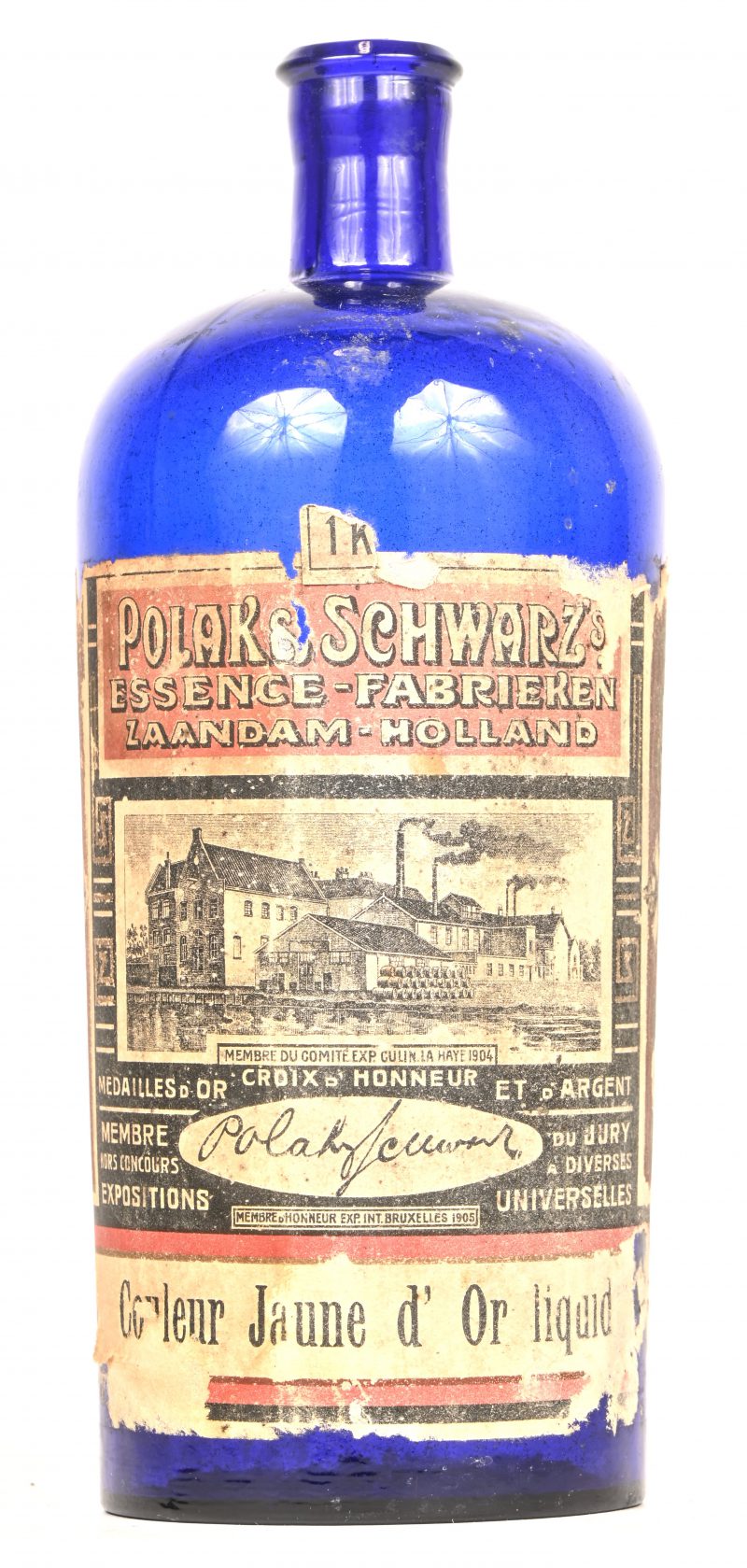 Een oude fles van de Essence-Fabriek Polak & Schwarz. Van blauw glas met het originele etiket grotendeels intact.
