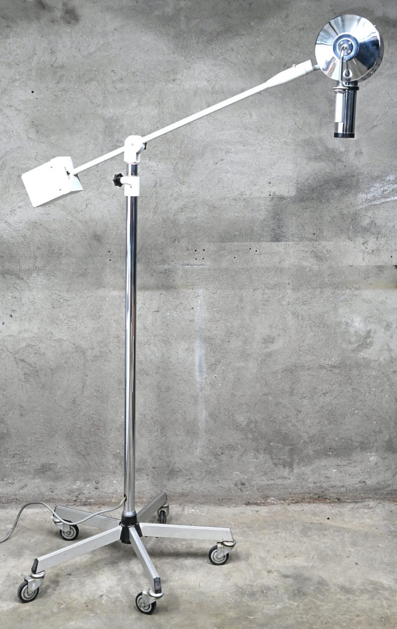 Een staande lamp op mobiele voet, vintage medisch materiaal.