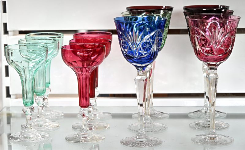 Een serie van zes gekleurde en geslepen sorbetglazen en een serie van zes grote wijnglazen van geslepen kristal in divere kleuren