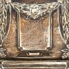 Een grote langwerpige milieu de table van gedreven zilver. Duitse keuren, 800/1000. Messingen binnenschaal. Decor met guirlandes. Opschrift m.b.t. een jubileum in het Osterriethuis in 1911.