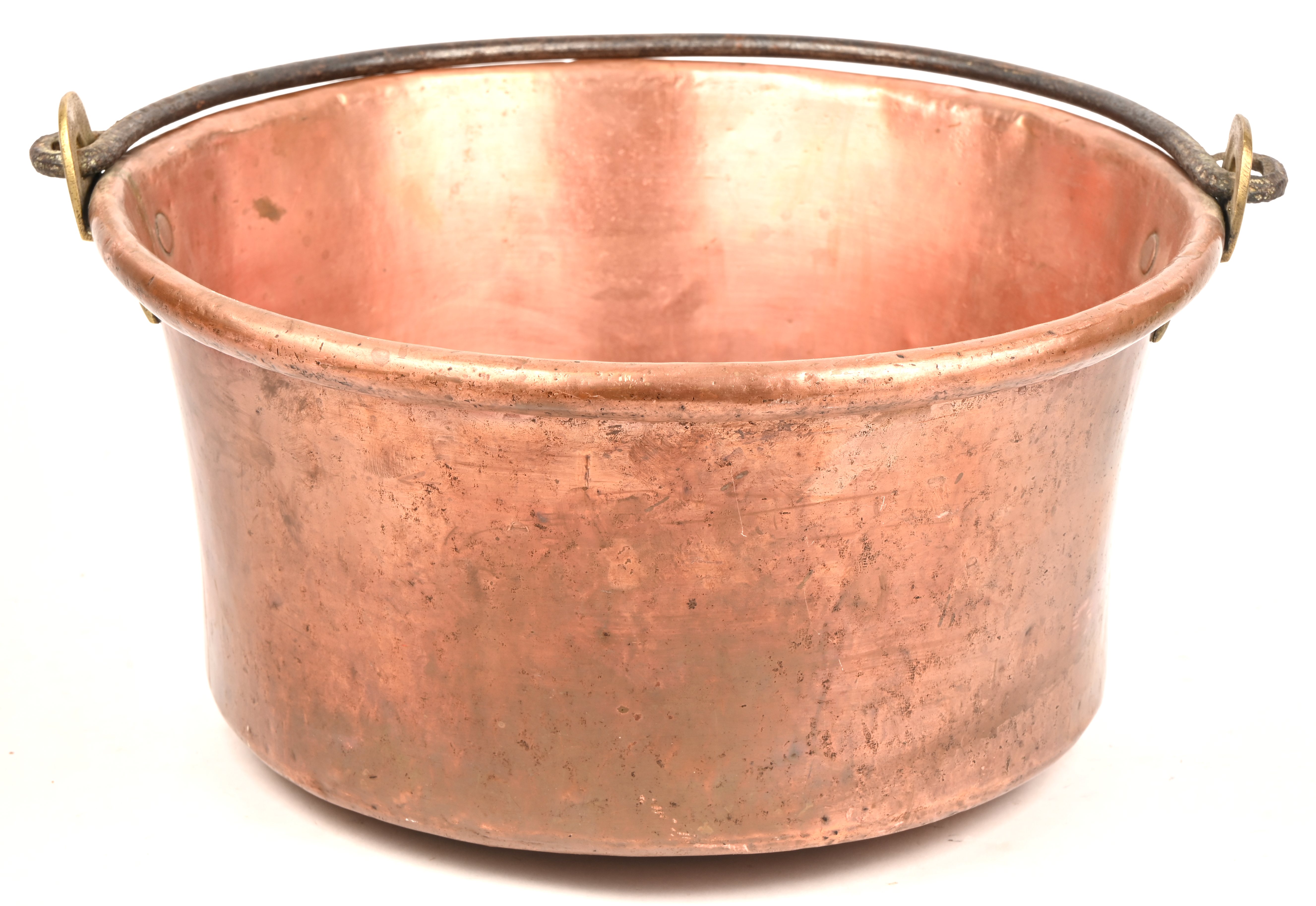 Een antieke rood koperen ketel met ijzeren handvat Een antieke rood koperen ketel met ijzeren handvat.