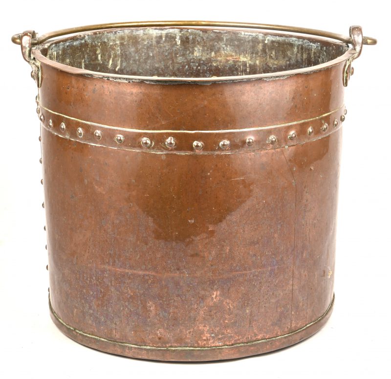 Een antieke rood koperen ketel met messing handvat.