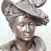 ‘Edeldame met verenhoed’, een buste van gepatinneerd brons. Getekend R. Gregoire.