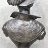 ‘Edeldame met verenhoed’, een buste van gepatinneerd brons. Getekend R. Gregoire.