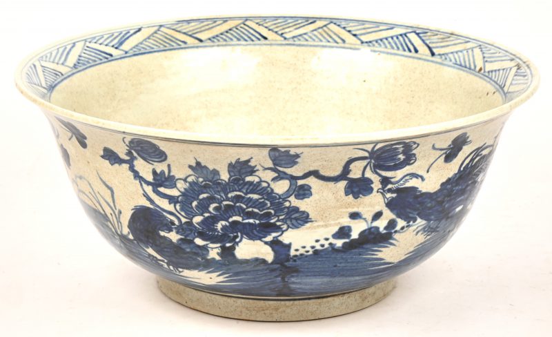 Een diepe schotel van blauw-wit geglazuurd Chinees porselein. Met een decor van vogels en bloemen. Niet gemerkt.